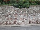 Mur au Bousquet-d'Orb, fait, de grs rouges, de calcaires, de basaltes